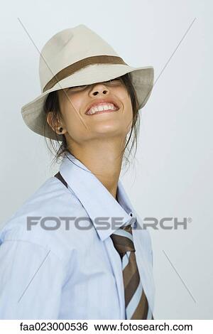 Teenage girl wearing tie and hat, smiling at camera, head back, portrait View Large Photo Image Stock Photograph - Teenage girl wearing tie and hat, smiling at camera, head back, portrait. Fotosearch