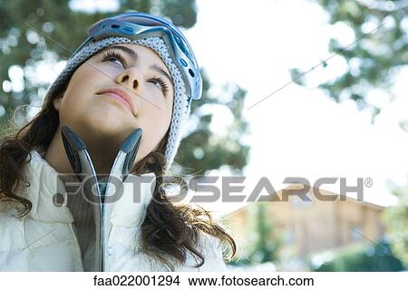 Teenage girl with skis, looking up View Large Photo Image Picture - Teenage girl with skis, looking up. Fotosearch