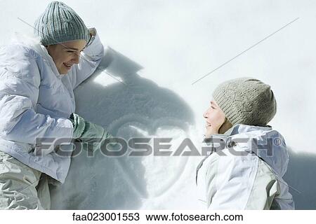 Teenage girls lying on snow, laughing, heart with initials drawn on surface of snow View Large Photo Image Stock Image - Teenage girls lying on snow, laughing, heart with initials drawn on surface of snow. Fotosearch