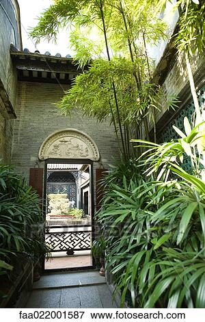 Stock Photo - Temple courtyard with lush foliage. Fotosearch
