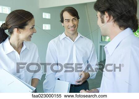 Three business associates chatting and smiling, waist up View Large Photo Image Stock Photography - Three business associates chatting and smiling, waist up. Fotosearch