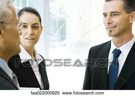 Three business associates chatting, cropped view View Large Photo Image Stock Image - Three business associates chatting, cropped view. Fotosearch