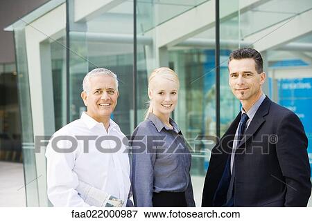 Three business associates smiling at camera, waist up, group portrait View Large Photo Image Stock Photo - Three business associates smiling at camera, waist up, group portrait. Fotosearch