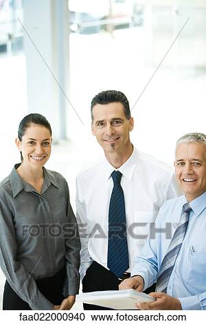 Three business associates standing together, smiling at camera View Large Photo Image Stock Image - Three business associates standing together, smiling at camera. Fotosearch