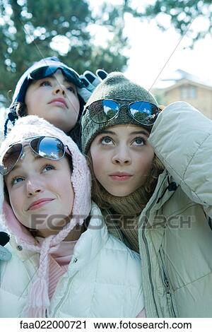 Three teen girls wearing winter clothes, lifting sunglasses and looking up, portrait View Large Photo Image Stock Image - Three teen girls wearing winter clothes, lifting sunglasses and looking up, portrait. Fotosearch