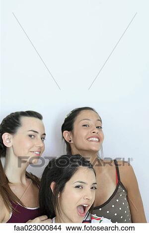 Three young female friends looking at camera, head and shoulders, portrait View Large Photo Image Picture - Three young female friends looking at camera, head and shoulders, portrait. Fotosearch