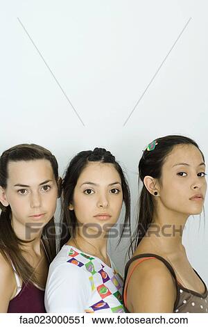 Stock Image - Three young friends, portrait, two looking at camera. Fotosearch