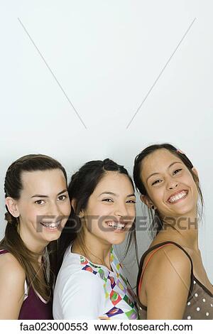 Three young friends smiling together, two looking at camera, portrait View Large Photo Image Stock Image - Three young friends smiling together, two looking at camera, portrait. Fotosearch