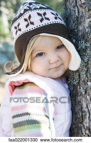 Toddler girl, leaning against tree trunk, looking at camera, portrait View Large Photo Image Stock Image - Toddler girl, leaning against tree trunk, looking at camera, portrait. Fotosearch
