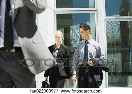 Two business associates walking together, chatting, three quarter length View Large Photo Image Stock Photo - Two business associates walking together, chatting, three quarter length. Fotosearch