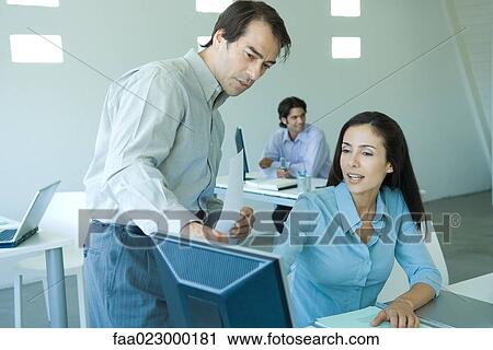 Two business colleagues looking at computer screen together View Large Photo Image Stock Image - Two business colleagues looking at computer screen together. Fotosearch