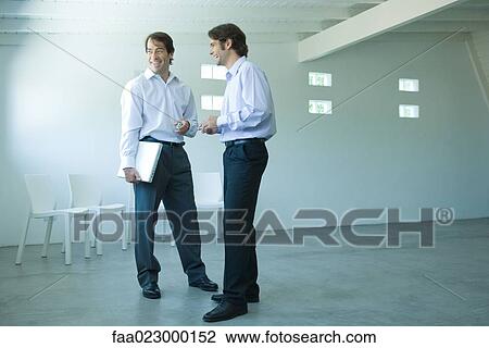 Two businessmen laughing, full length view View Large Photo Image Stock Image - Two businessmen laughing, full length view. Fotosearch