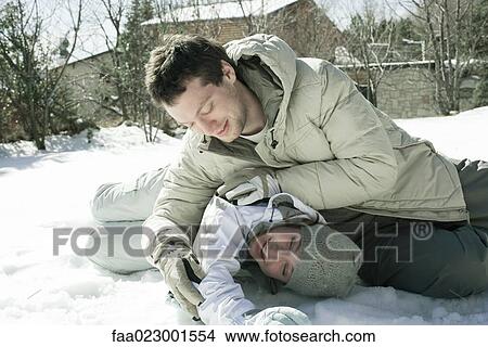 Picture - Two friends roughhousing outdoors in snow. Fotosearch