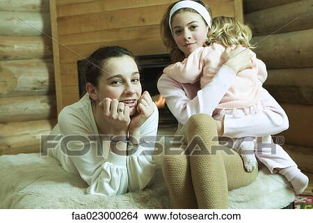 Two teen girls with little sister, smiling at camera View Large Photo Image Picture - Two teen girls with little sister, smiling at camera. Fotosearch