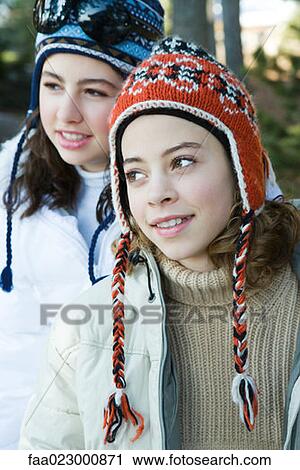 Two teenage girls wearing knit hats, smiling, looking away View Large Photo Image Stock Image - Two teenage girls wearing knit hats, smiling, looking away. Fotosearch