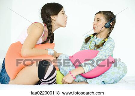 Two young female friends blowing bubbles with chewing gum View Large Photo Image Stock Photo - Two young female friends blowing bubbles with chewing gum. Fotosearch