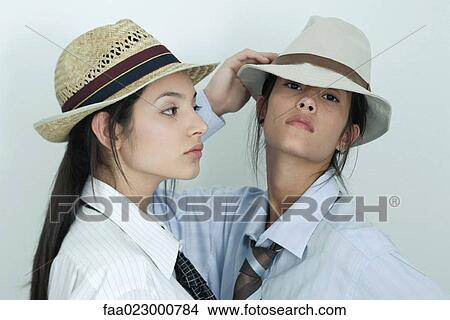Two young female friends dressed in button down shirts, ties and hats, portrait View Large Photo Image Picture - Two young female friends dressed in button down shirts, ties and hats, portrait. Fotosearch