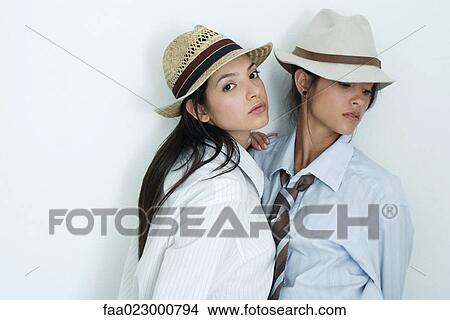 Two young female friends dressed in button down shirts, ties and hats, portrait View Large Photo Image Picture - Two young female friends dressed in button down shirts, ties and hats, portrait. Fotosearch