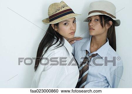 Two young female friends dressed in button down shirts, ties and hats, embracing, looking at camera, portrait View Large Photo Image Stock Image - Two young female friends dressed in button down shirts, ties and hats, embracing, looking at camera, portrait. Fotosearch