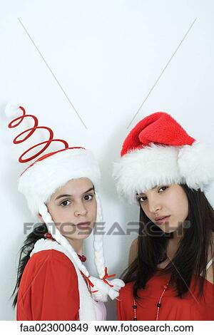 Two young female friends dressed in Christmas costumes, glaring at camera, portrait View Large Photo Image Stock Photo - Two young female friends dressed in Christmas costumes, glaring at camera, portrait. Fotosearch