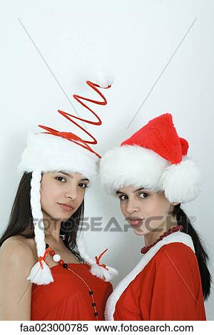 Two young female friends dressed in Christmas costumes, looking at camera, portrait View Large Photo Image Stock Photography - Two young female friends dressed in Christmas costumes, looking at camera, portrait. Fotosearch
