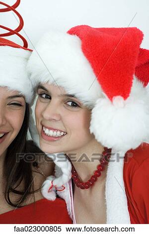Two young female friends dressed in Christmas costumes, smiling at camera, portrait View Large Photo Image Stock Photography - Two young female friends dressed in Christmas costumes, smiling at camera, portrait. Fotosearch