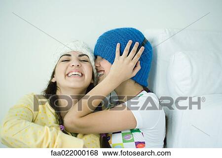 Two young female friends listening laughing View Large Photo Image Stock Photo - Two young female friends listening laughing. Fotosearch