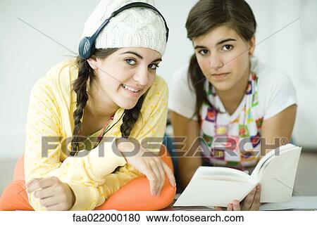 Two young female friends lying on floor, doing homework together View Large Photo Image Stock Image - Two young female friends lying on floor, doing homework together. Fotosearch