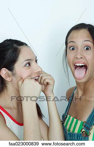 Two young female friends making faces, portrait View Large Photo Image Stock Photo - Two young female friends making faces, portrait. Fotosearch