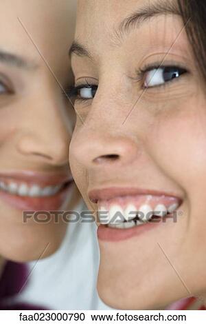 Two young female friends smiling at camera, extreme close-up of faces, cropped View Large Photo Image Stock Image - Two young female friends smiling at camera, extreme close-up of faces, cropped. Fotosearch