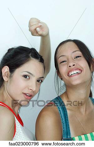 Two young female friends, smiling at camera, portrait View Large Photo Image Stock Photograph - Two young female friends, smiling at camera, portrait. Fotosearch