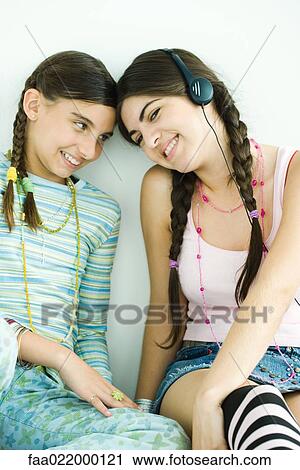 Stock Image - Two young female friends touching heads together. Fotosearch