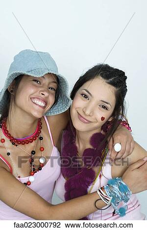 Two young female friends wearing lots of accessories, smiling at camera, portrait View Large Photo Image Stock Image - Two young female friends wearing lots of accessories, smiling at camera, portrait. Fotosearch