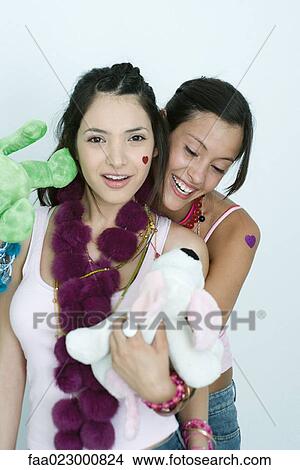 Picture - Two young female friends with stuffed animals, smiling at camera, portrait. Fotosearch