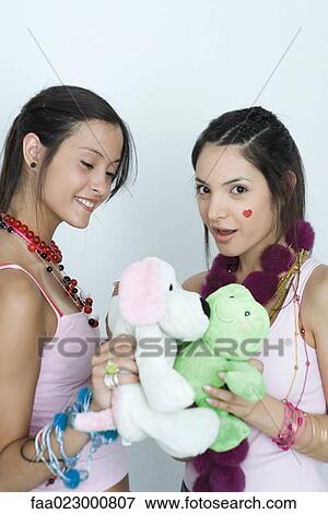 Stock Photo - Two young female friends with stuffed animals, portrait. Fotosearch