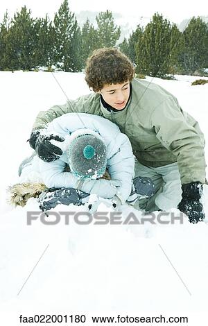 Two young friends crouching in snow, male's arm around female's shoulder, female's head down View Large Photo Image Stock Image - Two young friends crouching in snow, male's arm around female's shoulder, female's head down. Fotosearch