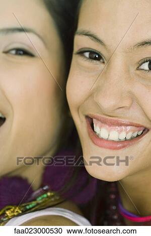 Two young friends smiling at camera together, cheek to cheek, cropped view View Large Photo Image Stock Image - Two young friends smiling at camera together, cheek to cheek, cropped view. Fotosearch