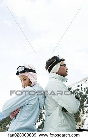 Two young friends standing back to back, arms folded, looking away, dressed in winter clothing View Large Photo Image Stock Photo - Two young friends standing back to back, arms folded, looking away, dressed in winter clothing. Fotosearch