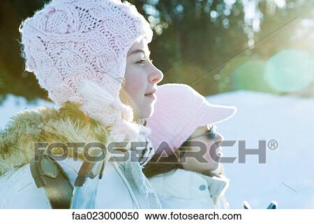 Two young friends standing side by side, wearing hats, looking away View Large Photo Image Stock Image - Two young friends standing side by side, wearing hats, looking away. Fotosearch