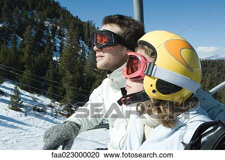 Two young skiers on chair lift, looking away, side view View Large Photo Image Stock Image - Two young skiers on chair lift, looking away, side view. Fotosearch