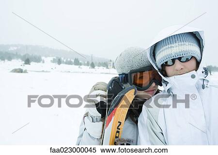 Two young skiers standing side by side, looking at camera, one's head on the other's shoulder View Large Photo Image Stock Photography - Two young skiers standing side by side, looking at camera, one's head on the other's shoulder. Fotosearch