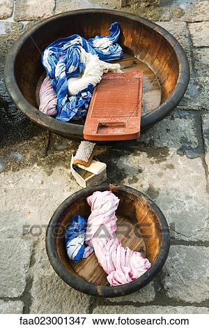 Wash bassins with washboard and twisted wet laundry View Large Photo Image Stock Photo - Wash bassins with washboard and twisted wet laundry. Fotosearch