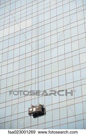 Window washers cleaning side of skyscraper View Large Photo Image Stock Photo - Window washers cleaning side of skyscraper. Fotosearch