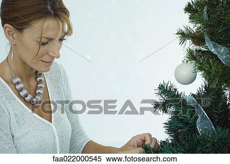 Woman decorating Christmas tree View Large Photo Image Stock Photography - Woman decorating Christmas tree. Fotosearch