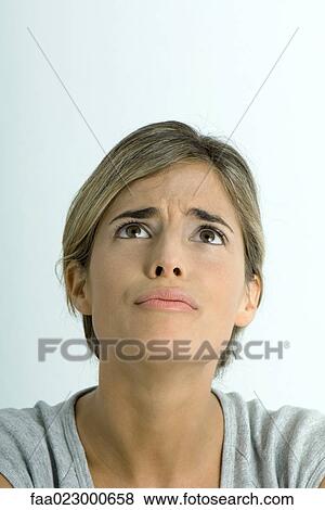 Woman furrowing brow, looking up, portrait View Large Photo Image Stock Photo - Woman furrowing brow, looking up, portrait. Fotosearch