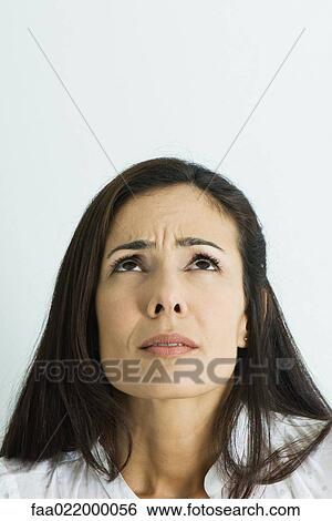 Woman furrowing brow, looking up, portrait View Large Photo Image Stock Photograph - Woman furrowing brow, looking up, portrait. Fotosearch
