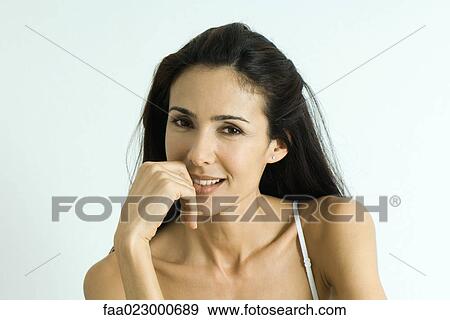 Woman holding hand near mouth, smiling at camera, portrait View Large Photo Image Stock Photo - Woman holding hand near mouth, smiling at camera, portrait. Fotosearch