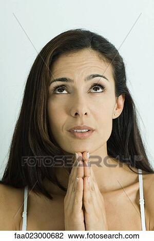 Woman holding hands in prayer, looking up, portrait View Large Photo Image Stock Image - Woman holding hands in prayer, looking up, portrait. Fotosearch