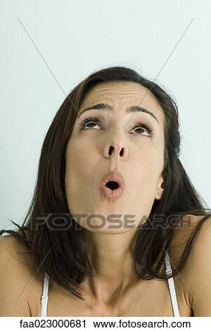 Stock Image - Woman looking up, surprised, portrait. Fotosearch