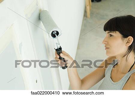 Woman painting door with paint roller View Large Photo Image Stock Image - Woman painting door with paint roller. Fotosearch